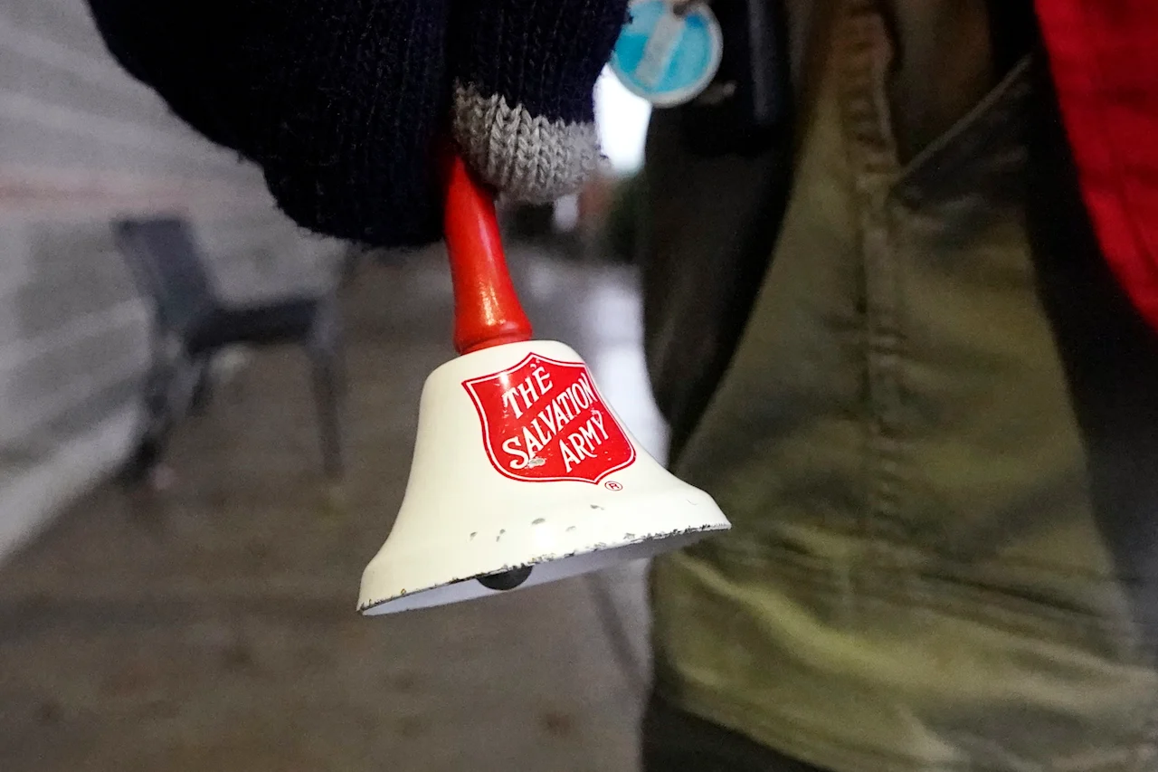 FILE - A Salvation Army bell is rung by Michael Cronin as he staffs the charity's red donation kettle in front of a grocery store, Tuesday, Dec. 8, 2020, in Lynden, Wash. In the wake of the most devastating public-health emergency in a century and the resulting economic uncertainty, Americans provided more charitable dollars to United Way Worldwide than any other nonprofit focused on direct aid, followed by the Salvation Army and St. Jude Children’s Research Hospital, according to new rankings by the Chronicle of Philanthropy. (AP Photo/Elaine Thompson, File)