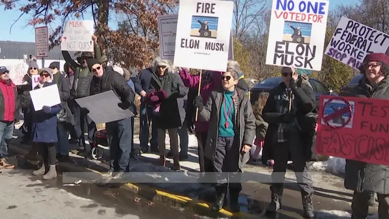 Story image: Nearly 300 demonstrators gather at Mount Kisco Tesla showroom to protest DOGE job and program cuts