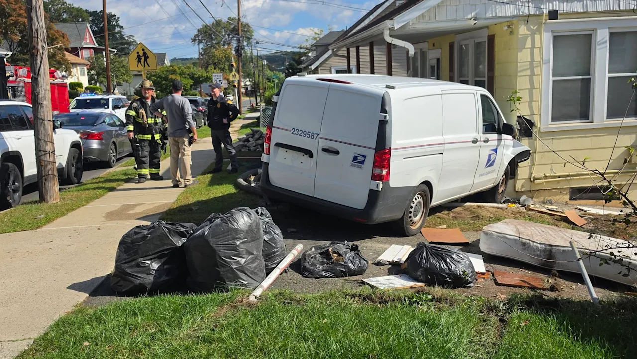 USPS van crashes into house