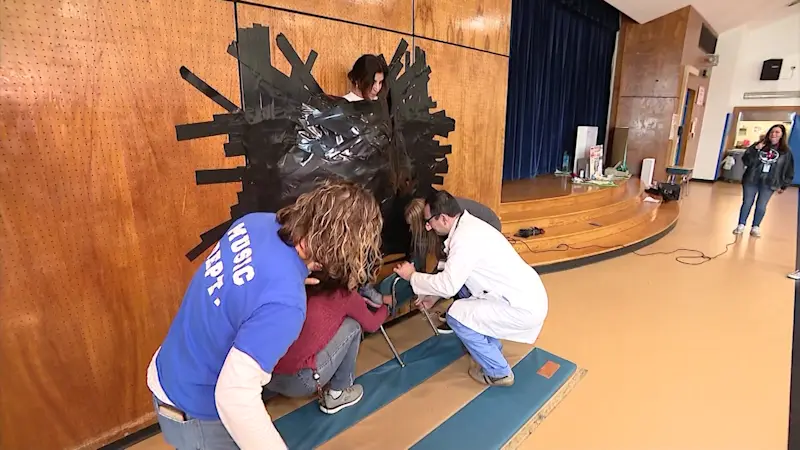 Story image: Oakdale principal allows students to duct tape her to wall for sake of science