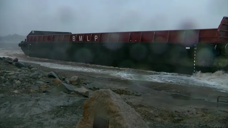 Story image: Salvage crews on site after barges wash ashore in Milford, but rough weather delays recovery