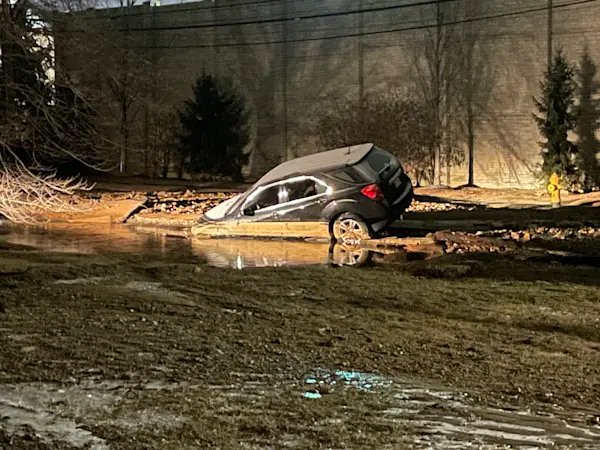 Story image: Water main break traps a car in a sinkhole in Wayne