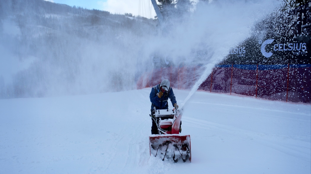 Jen Steeves, a section chief with the Beaver Creek race department, blows snow off the course in blustery conditions